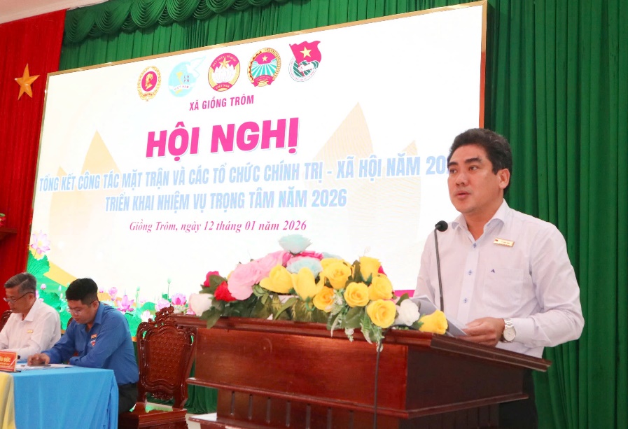 Description: A person standing at a podium with a microphone

AI-generated content may be incorrect.